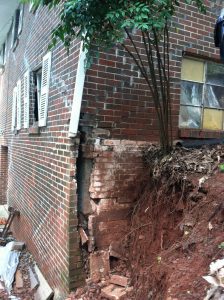 Picture of exterior home wall collapsed with dirt cascading
