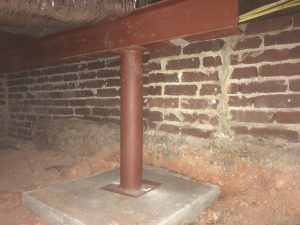 Basement crawl space with single steel support column on concrete footing